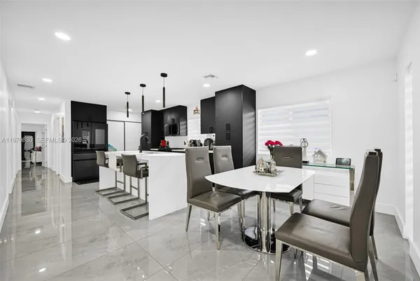 a kitchen with stainless steel appliances kitchen island granite countertop a sink and a refrigerator