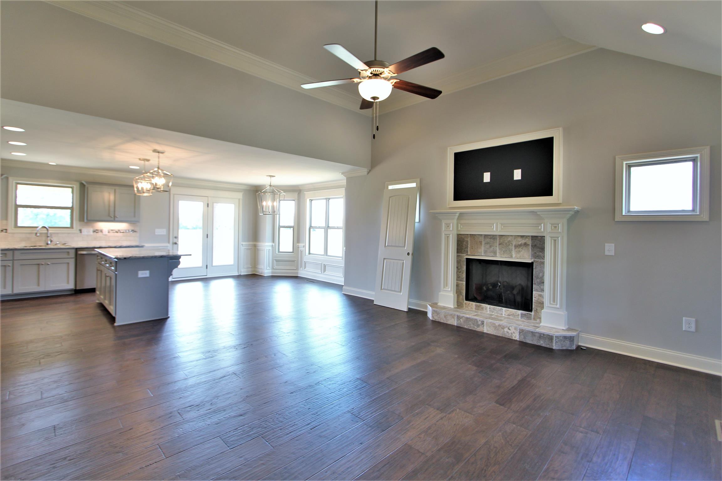 6620 Murfreesboro Road, Unit 29 Lebanon, TN 37090 - Photo 6 of 23 a view of a livingroom with a fireplace a ceiling fan and a kitchen space
