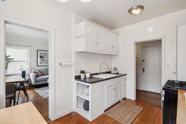 a kitchen with stainless steel appliances granite countertop a stove and a view of living room