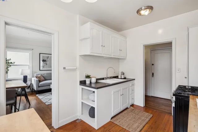 a kitchen with stainless steel appliances granite countertop a stove and a view of living room
