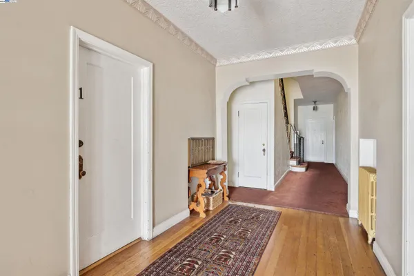 a view of a hallway view with wooden floor and a rug