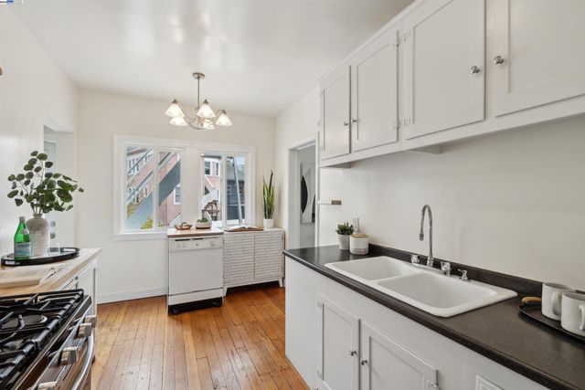 a kitchen with granite countertop a sink stove and cabinets