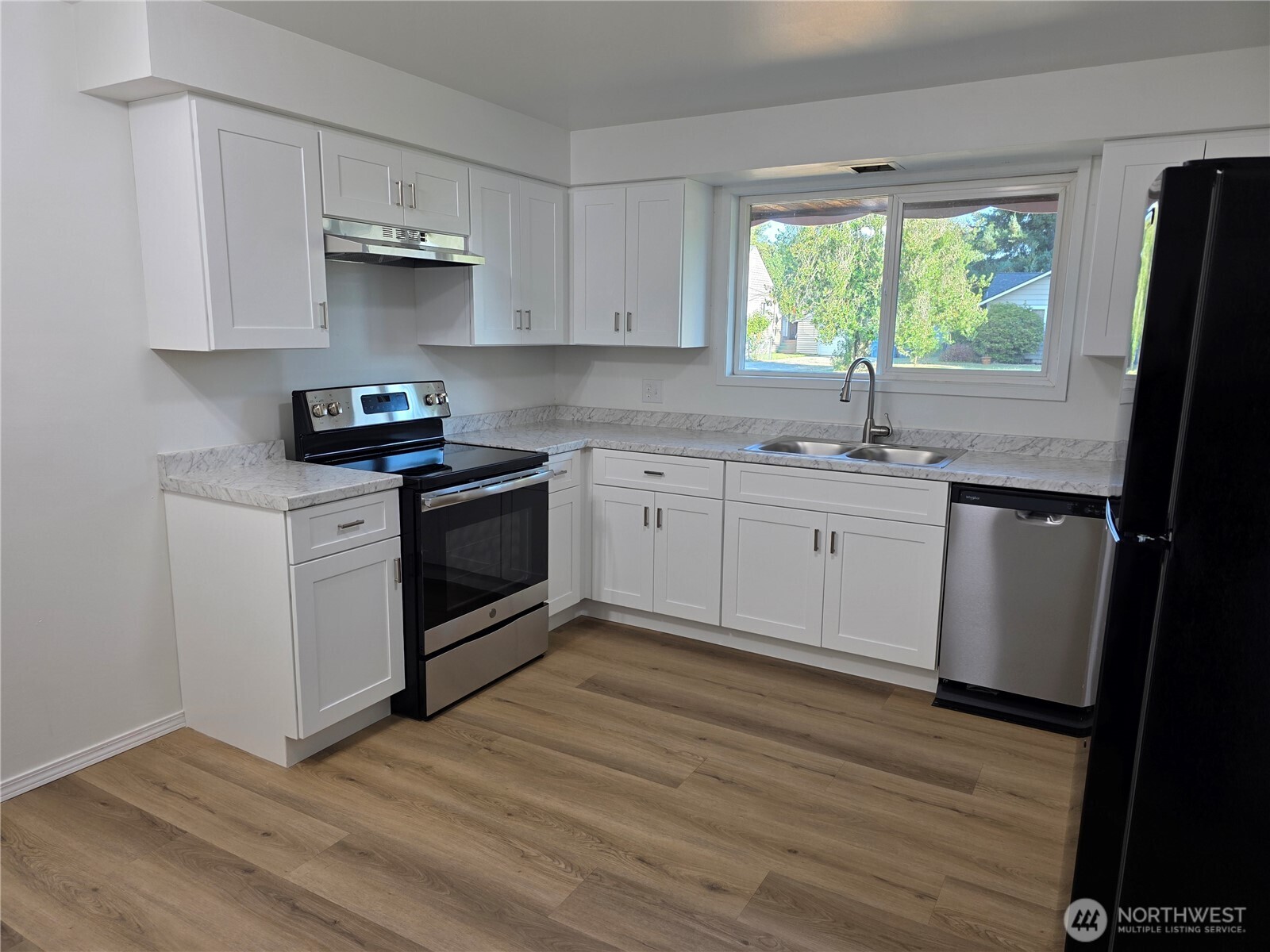 620 North Street Monroe, WA 98272 - Photo 29 of 38 a kitchen with stainless steel appliances granite countertop wooden floors a stove a sink and a window