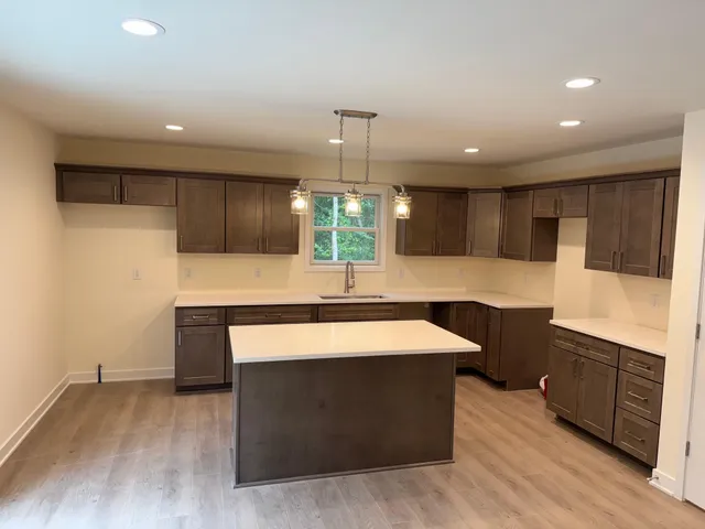 a kitchen with stainless steel appliances kitchen island granite countertop a stove a sink and a refrigerator