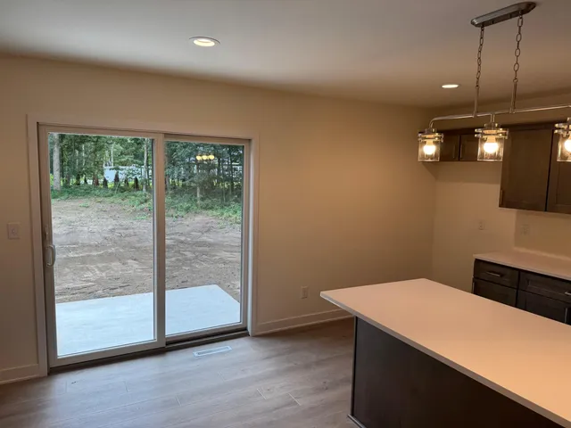 a view of a room with wooden floor and a ceiling fan