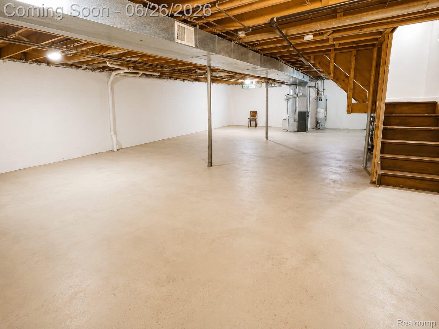 17014 Country Ridge Lane Macomb, MI 48044 - Photo 21 of 25 Expansive unfinished basement featuring concrete flooring, exposed ceiling joists, white painted walls, and a wooden staircase