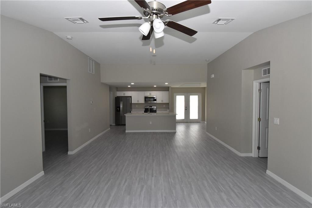 2121 Firebrand Road North Port, FL 34288 - Photo 5 of 22 Unfurnished living room featuring french doors, vaulted ceiling, dark wood-type flooring, and a ceiling fan