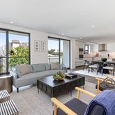 a living room with furniture kitchen view and a large window
