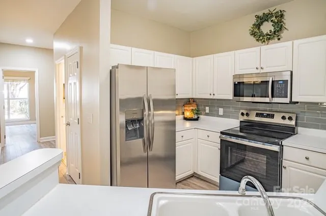 a kitchen with a refrigerator a stove and a sink