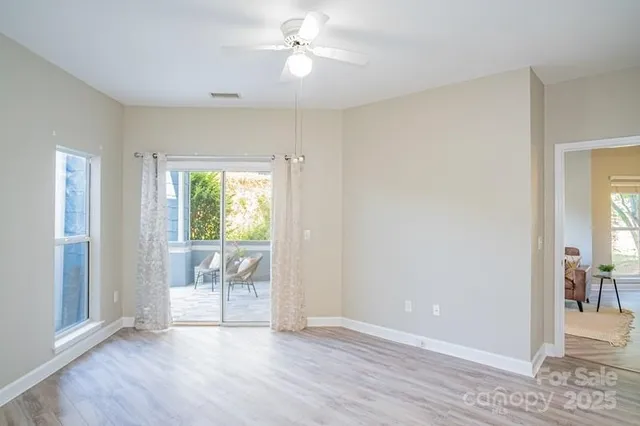 a view of a room with wooden floor and a ceiling fan