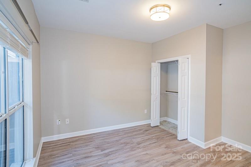 1125 Torrence Circle Davidson, NC 28036 - Photo 21 of 41 a view of an empty room with wooden floor and a window