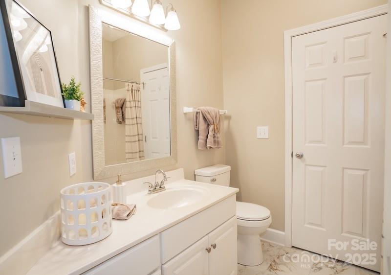 1125 Torrence Circle Davidson, NC 28036 - Photo 23 of 41 a bathroom with a granite countertop sink a toilet and a mirror