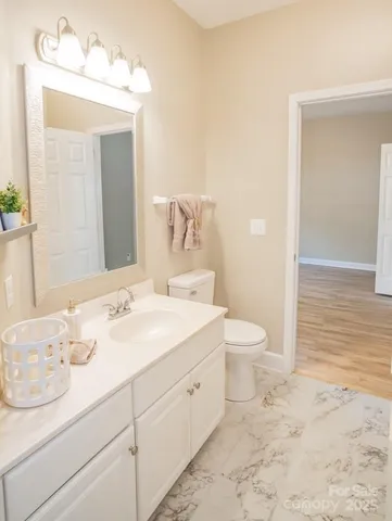 a bathroom with a granite countertop sink a toilet and a mirror
