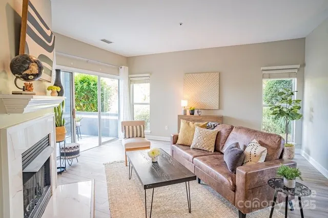 a living room with furniture fireplace and a large window