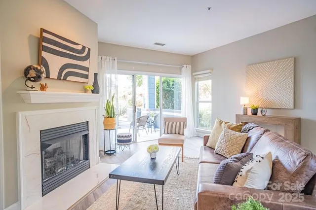 a living room with furniture a fireplace and a large window