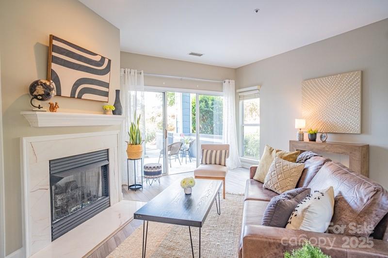 1125 Torrence Circle Davidson, NC 28036 - Photo 7 of 41 a living room with furniture a fireplace and a large window
