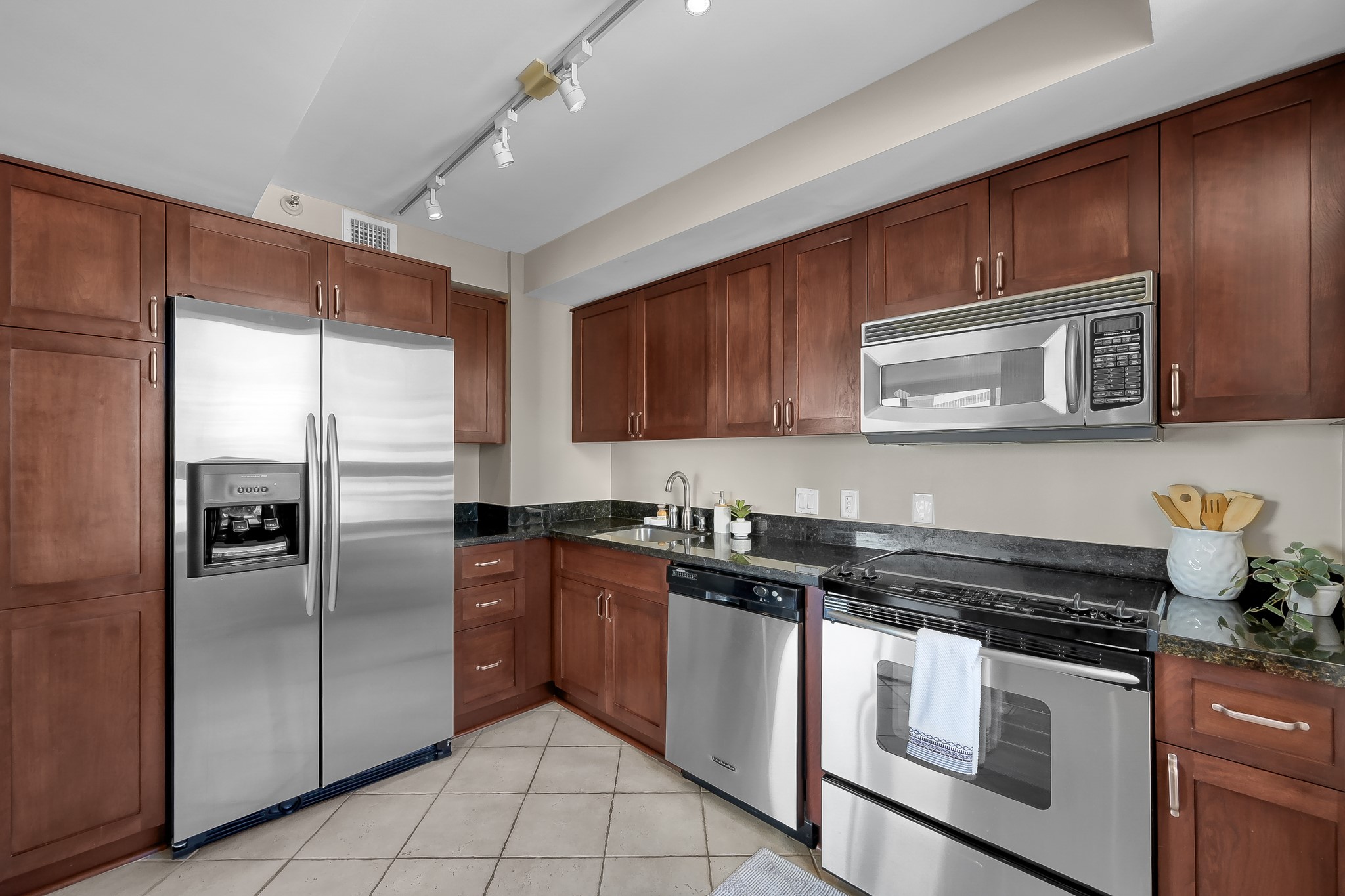 1111 Caroline Street, Unit 2901 Houston, TX 77010 - Photo 15 of 46 a kitchen with stainless steel appliances granite countertop a stove microwave and refrigerator