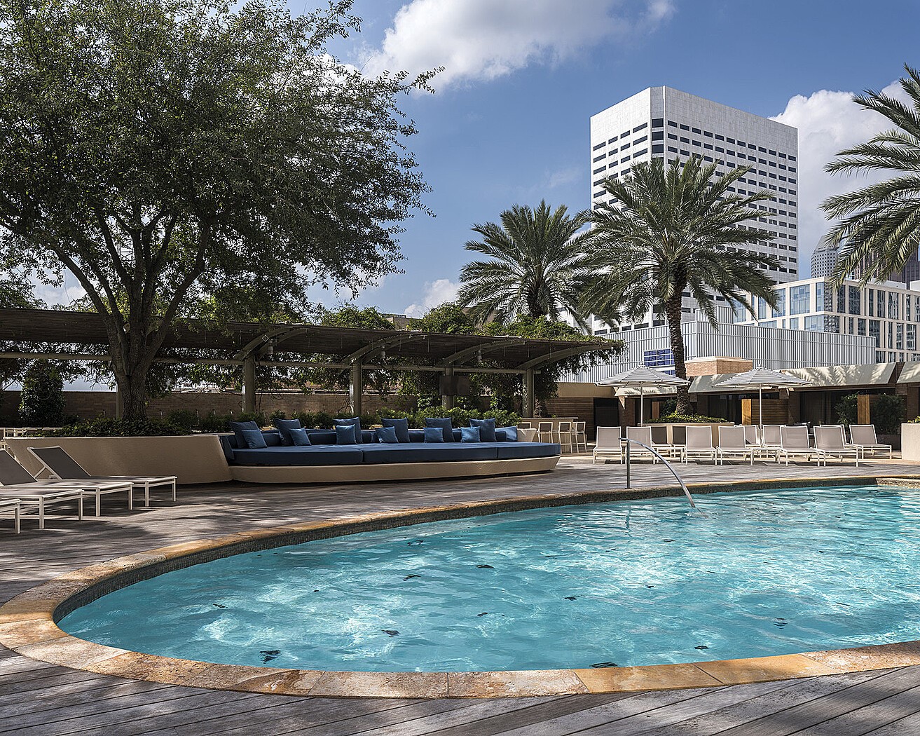 1111 Caroline Street, Unit 2901 Houston, TX 77010 - Photo 28 of 46 a view of a swimming pool with a lawn chairs and palm tree