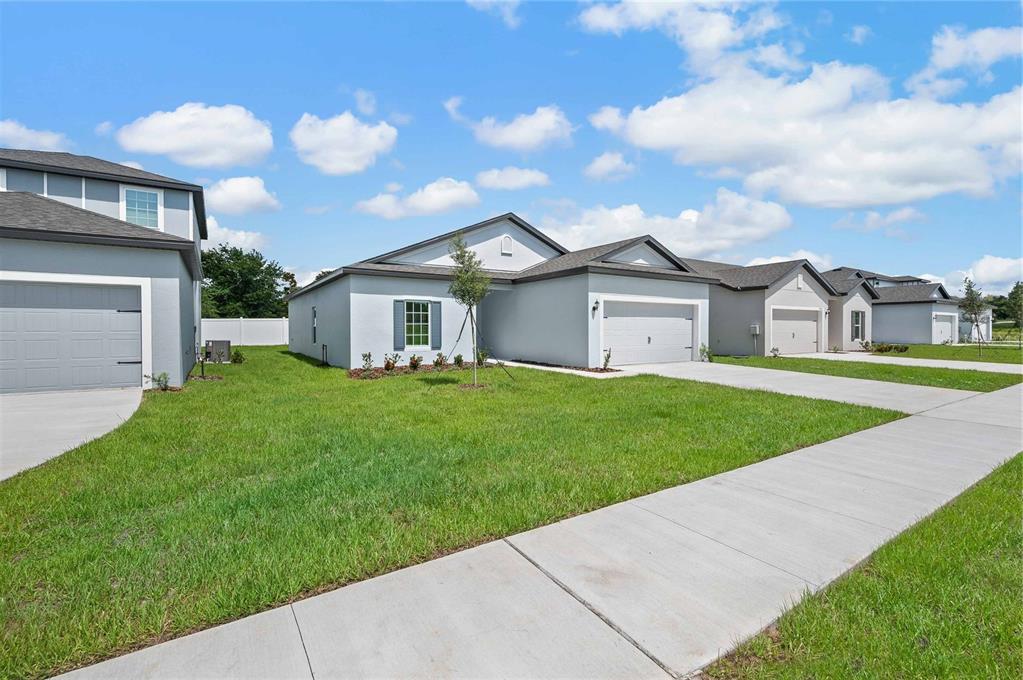 13261 Tula Loop Astatula, FL 34705 - Photo 3 of 25 a view of a house next to a big yard and large trees
