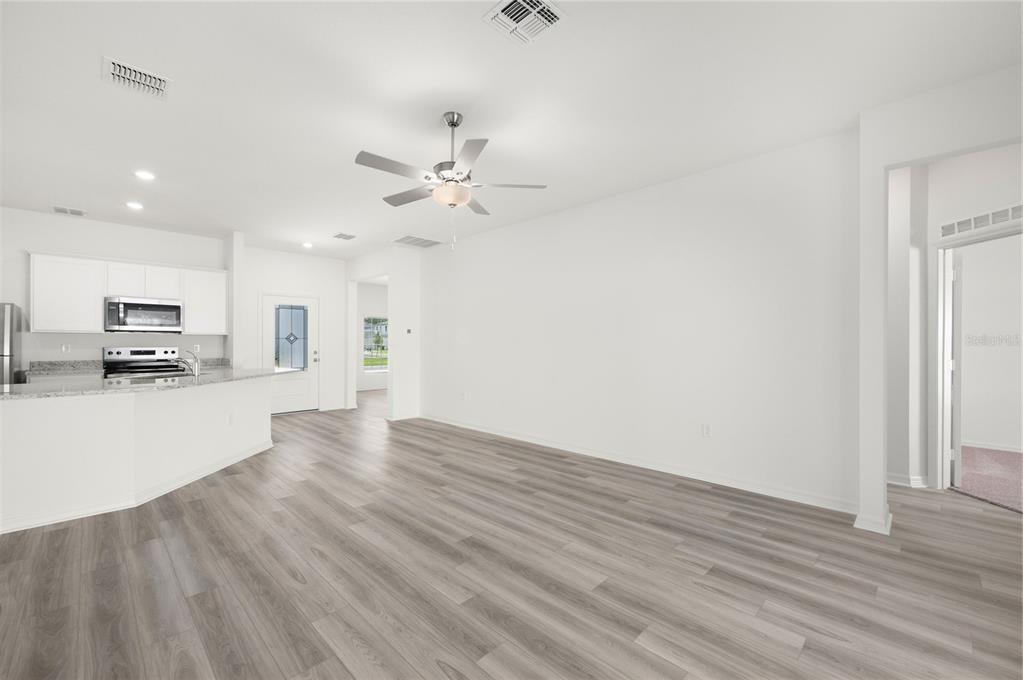 13261 Tula Loop Astatula, FL 34705 - Photo 8 of 25 a view of kitchen with microwave and wooden floor