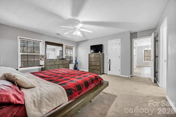 a bedroom with a large bed and a chandelier