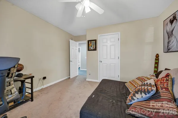a bedroom with furniture and a chandelier fan