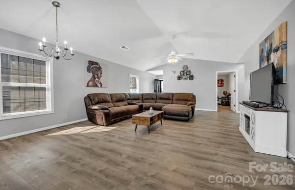 a living room with furniture a chandelier and a flat screen tv