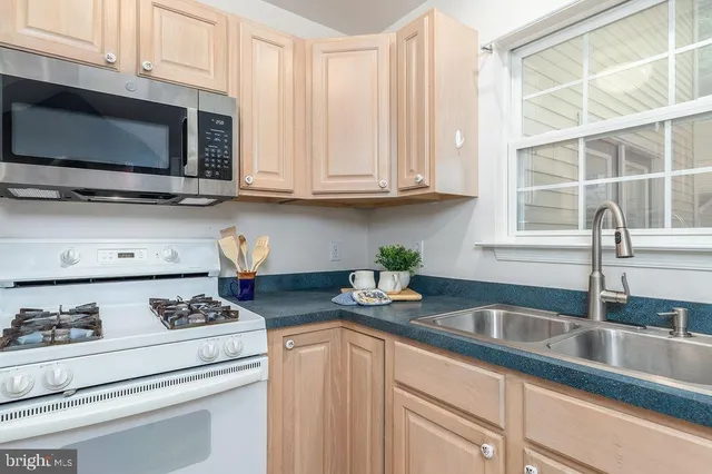 a kitchen with appliances a sink and cabinets