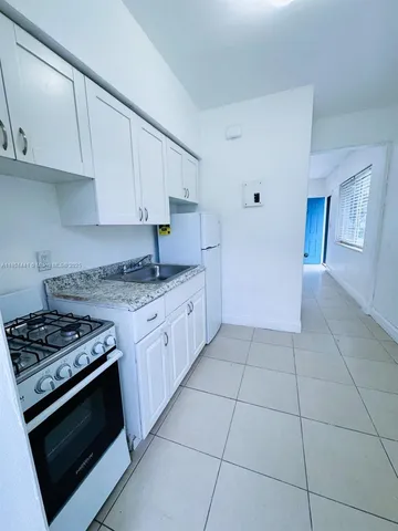 a kitchen with stainless steel appliances a stove a microwave and a sink