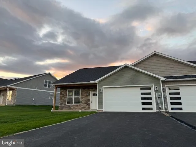 a front view of a house with a garden and yard