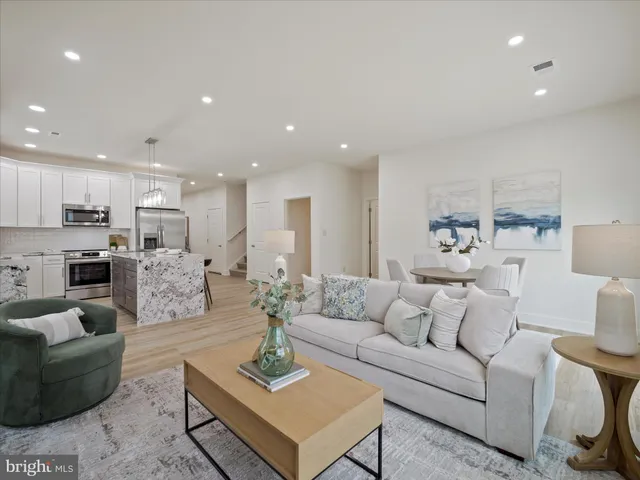 a living room with furniture kitchen view and a table