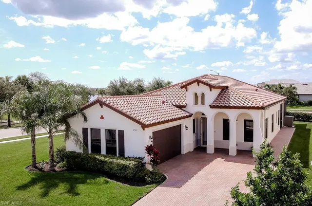 a view of a white house with a big yard and potted plants