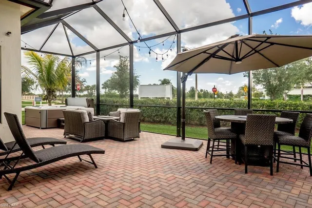 a view of a patio with a table chairs and a yard