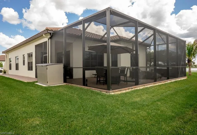 a view of a house with a yard and a wooden fence