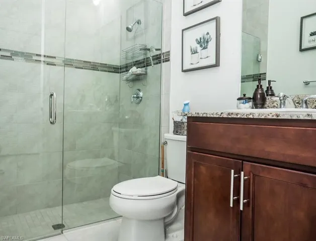 a bathroom with a granite countertop toilet sink and shower