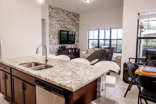a kitchen with granite countertop a sink and a wooden floor