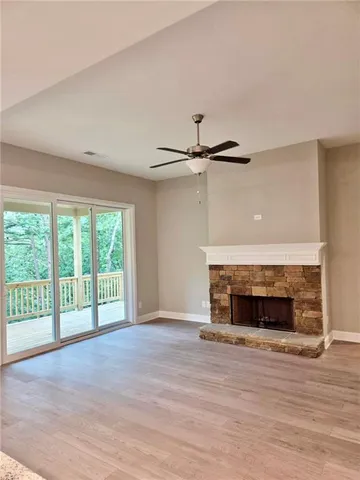 a view of empty room with wooden floor and fireplace