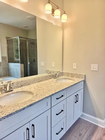 a bathroom with a granite countertop sink and large mirror