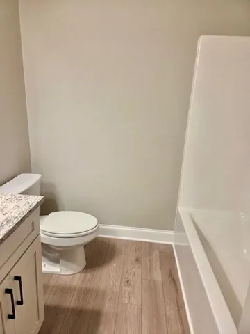 a white toilet sitting next to a shower