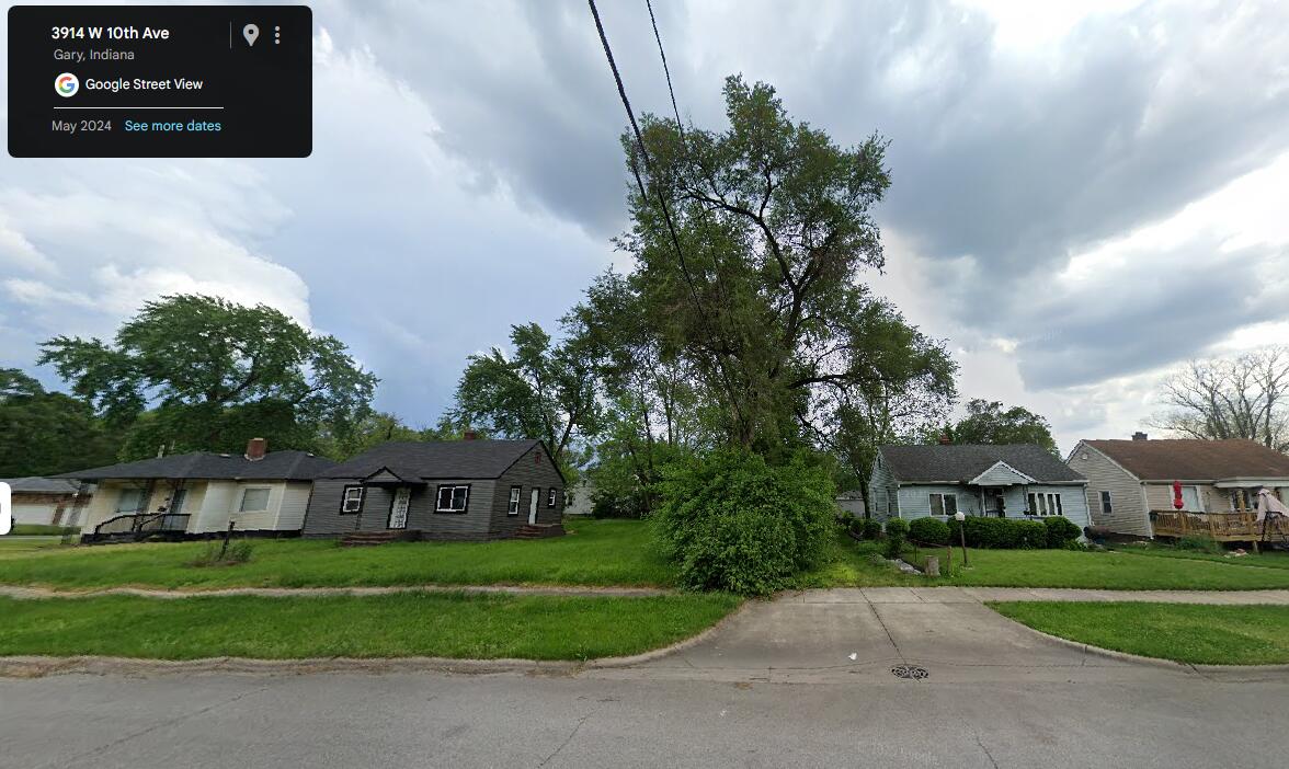 3911 West 10th Avenue Gary, IN 46404 - Photo 4 of 7 a view of a big house with a big yard and large trees
