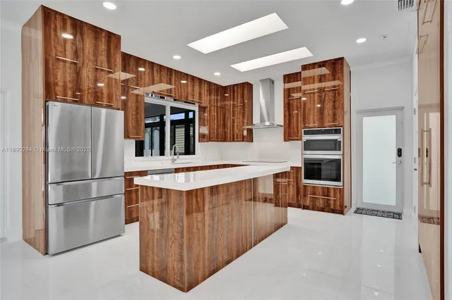 a kitchen with stainless steel appliances a refrigerator and a stove top oven