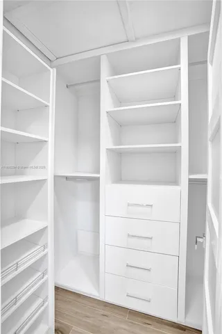 a view of walk in closet with empty racks