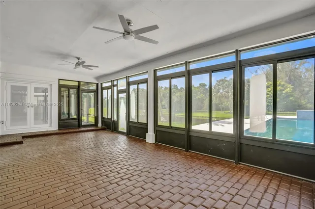 a view of an empty room with window and a ceiling fan