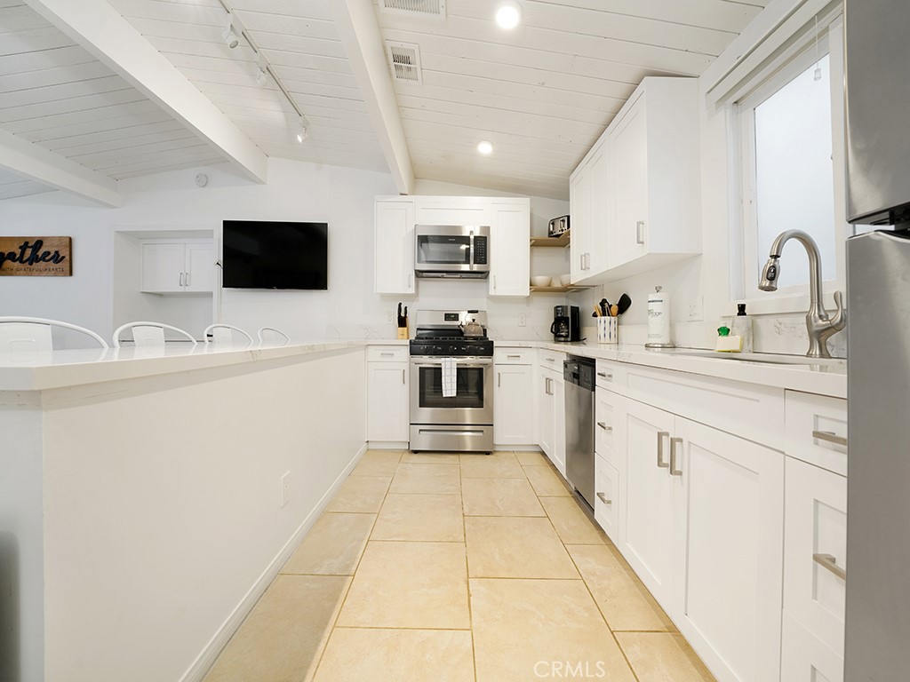 129 45th Street Newport Beach, CA 92663 - Photo 19 of 38 a kitchen with a sink a counter top space stainless steel appliances and cabinets