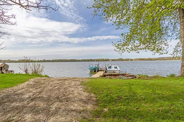 a view of a lake with a big yard and large trees