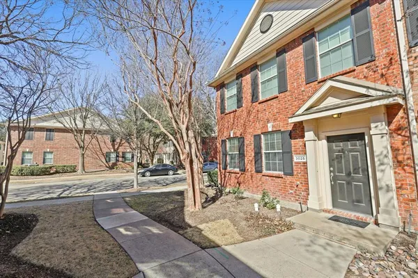 a view of a brick building next to a yard