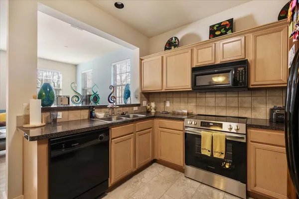 a kitchen with stainless steel appliances granite countertop wooden cabinets stove top oven and microwave