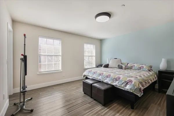 a bedroom with a bed and wooden floor