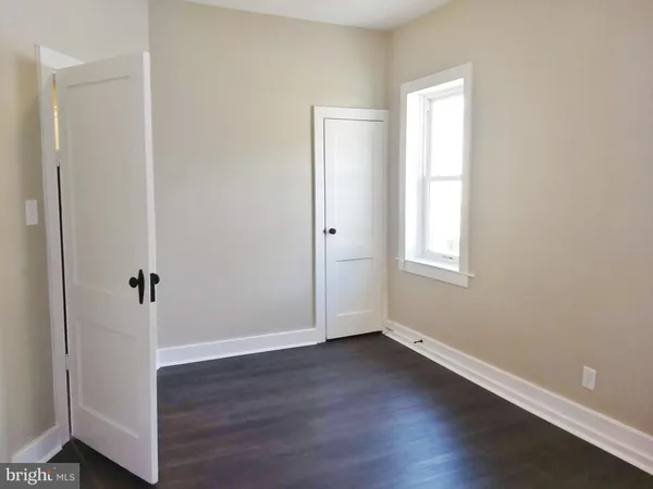an empty room with wooden floor and window