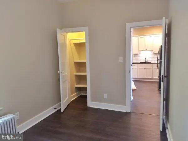 an empty room with wooden floor and a window